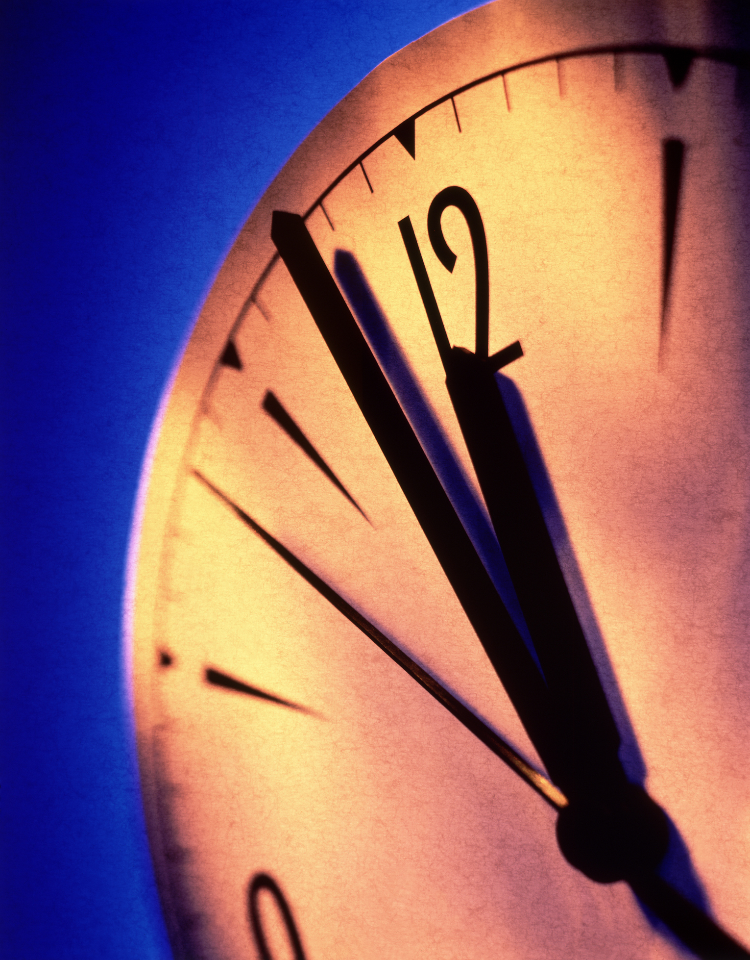 Close-up of a clock showing the time at one minute past twelve