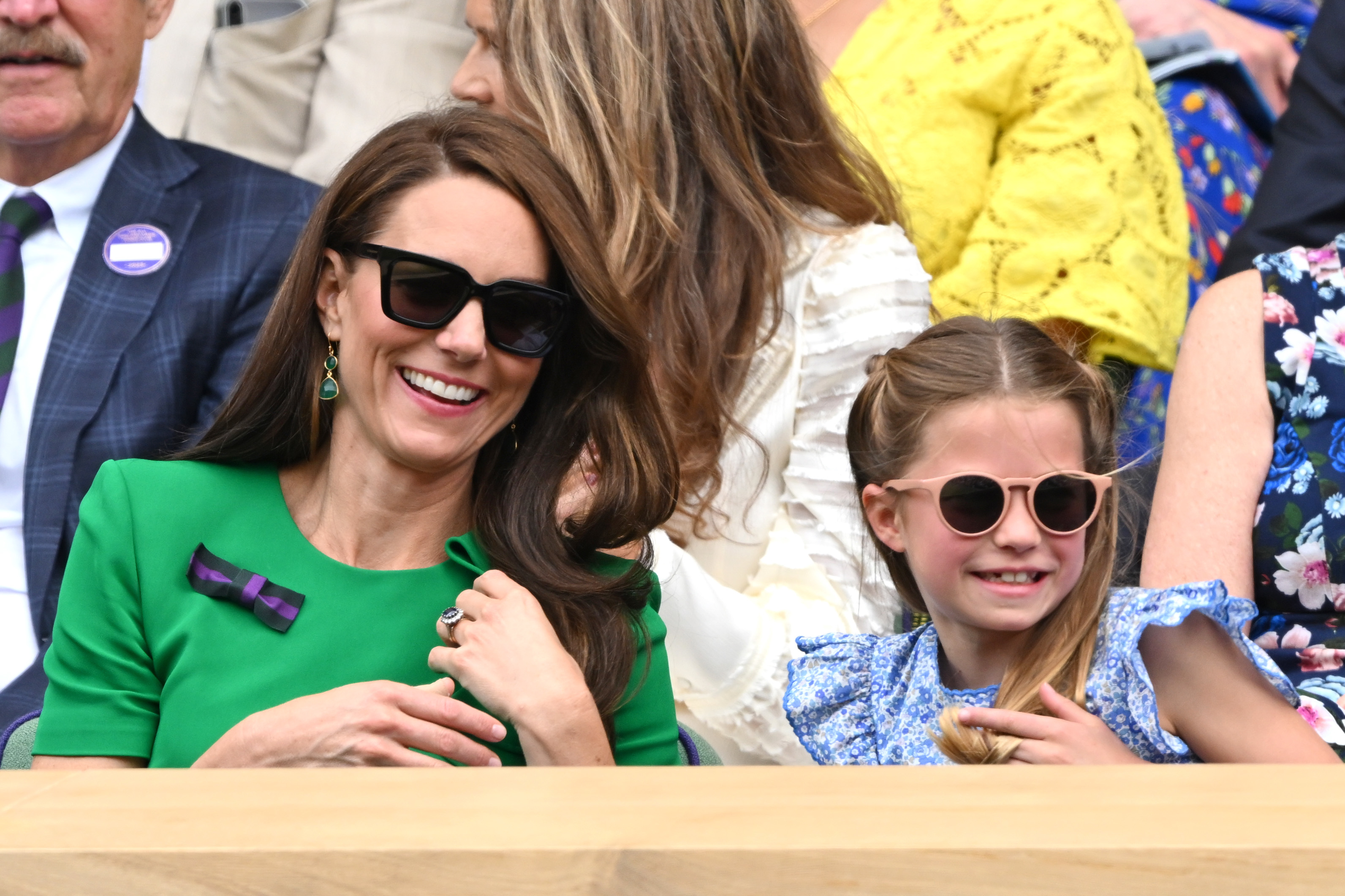 Kate Middleton and Princess Charlotte wearing sunglasses and smiling while sitting outdoors