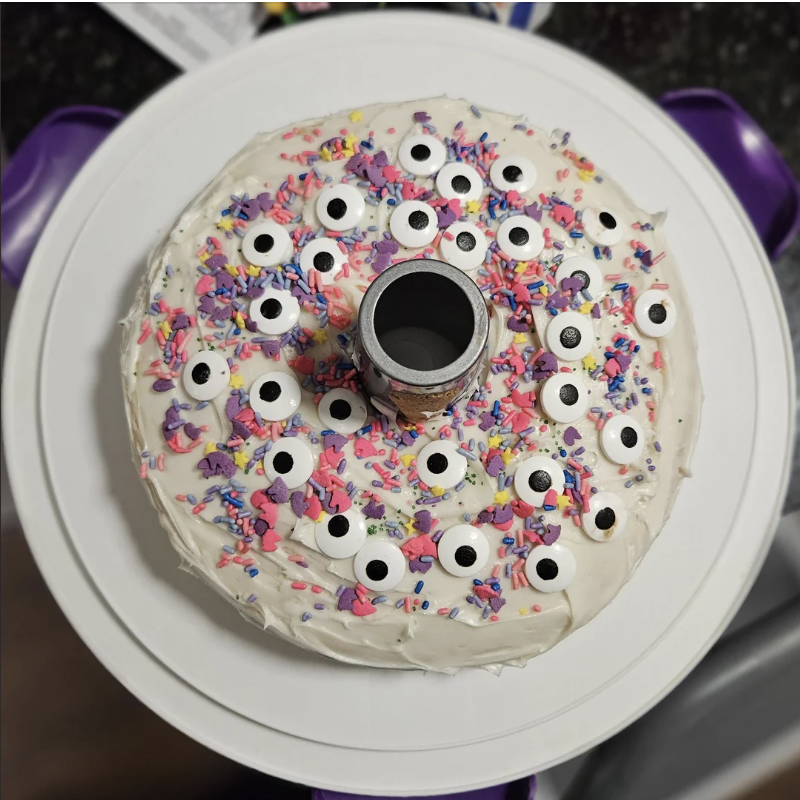 Bundt cake decorated with googly eye candies and colorful sprinkles on a plate