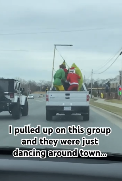 Santa Claus, the Grinch, and a person in a yellow costume dance in the back of a moving pickup truck. Text: &quot;I pulled up on this group and they were just dancing around town...&quot;