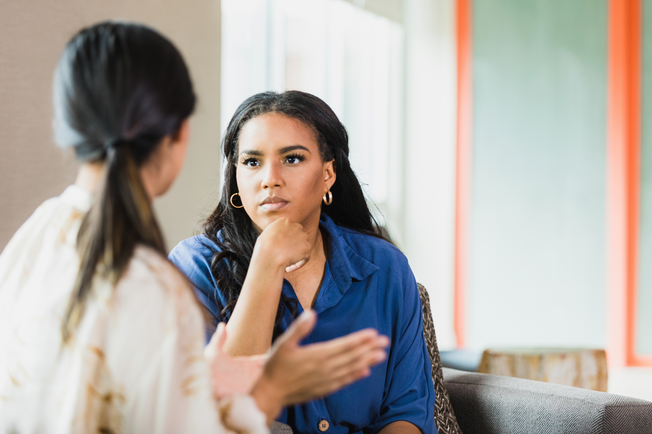 Two women having an engaged conversation indoors