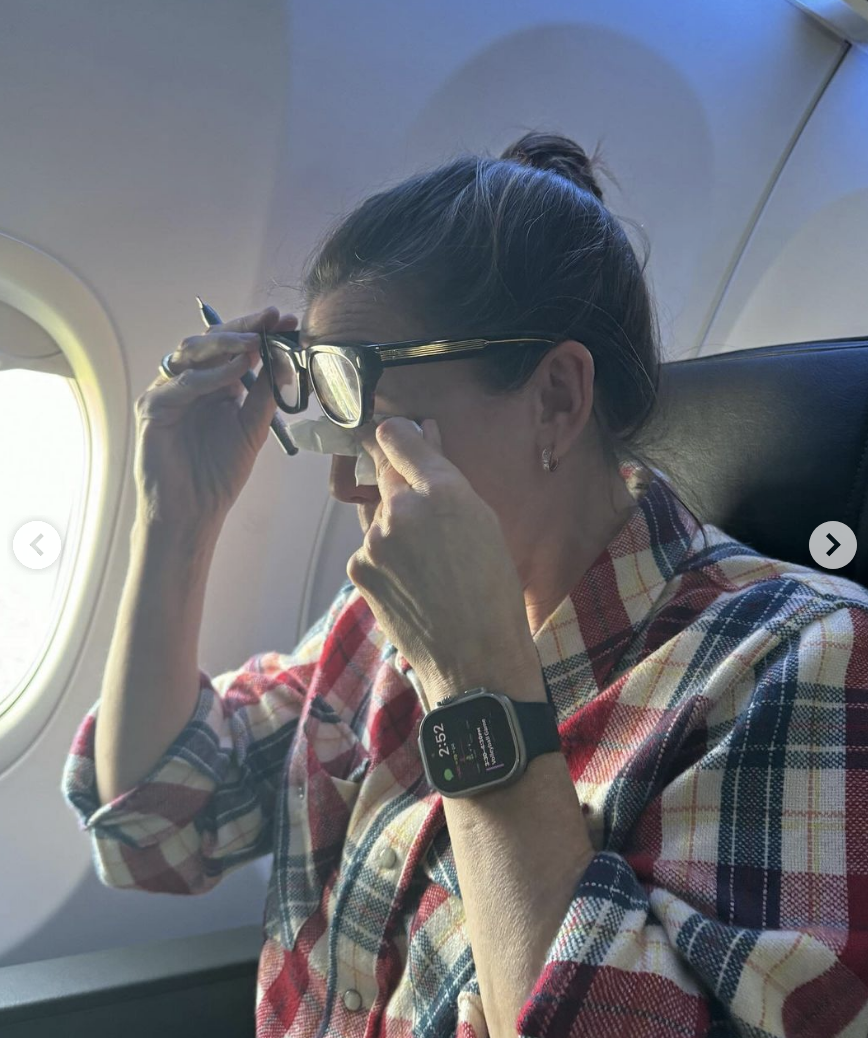 Jennifer Garner wiping her eyes on an airplane