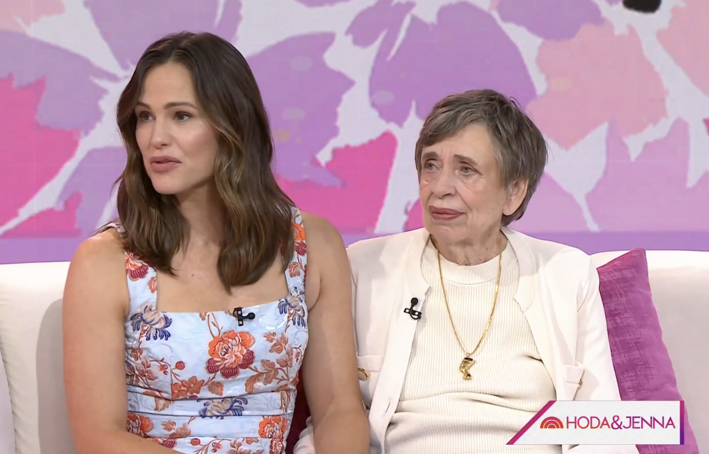 Jennifer Garner and her mother are seated on a talk show set, with the &quot;Hoda &amp;amp; Jenna&quot; logo visible in the corner. Jennifer is wearing a floral dress