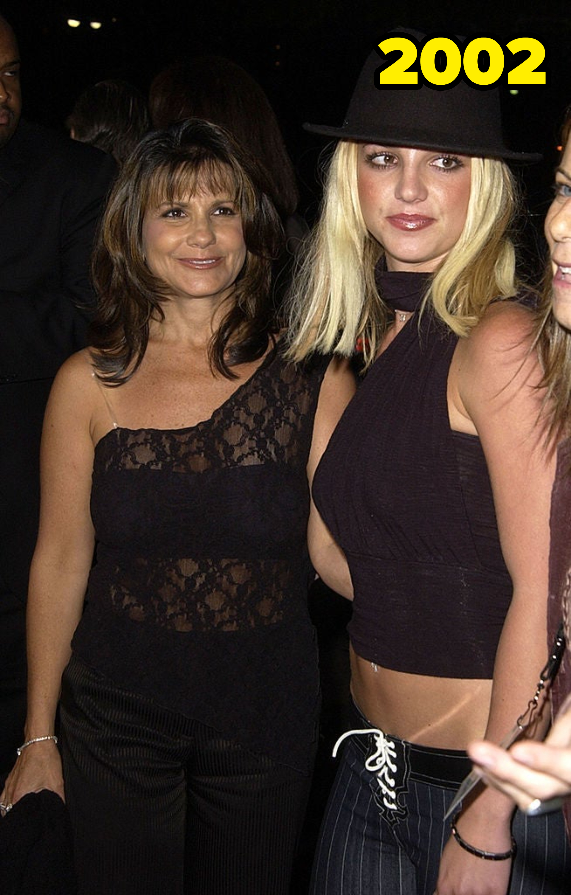 Lynne Spears in a lace top and Britney Spears in a dark top and hat smile at an event