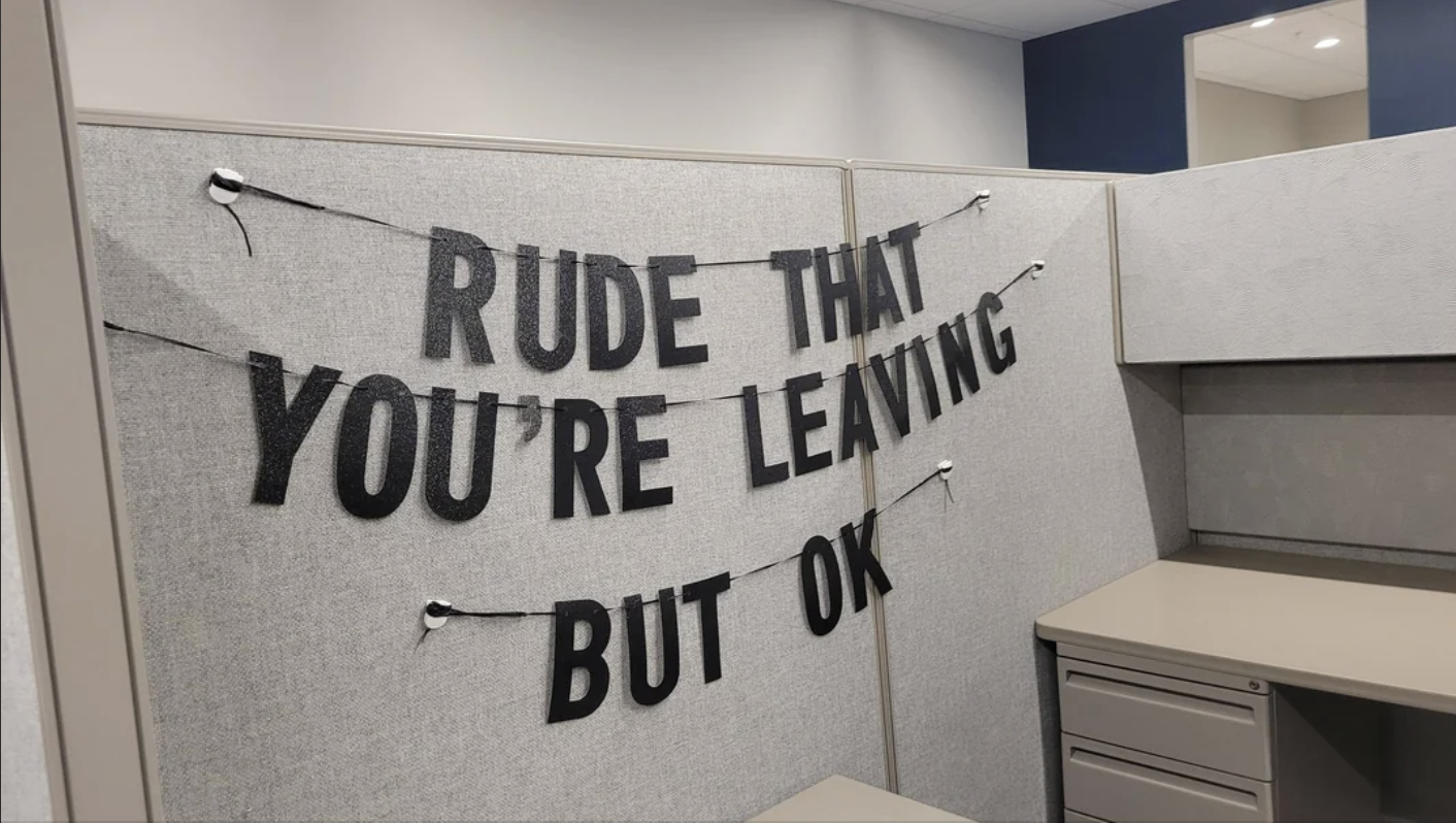 Decorative banner in an office cubicle reads, &quot;Rude that you&#x27;re leaving but ok&quot;