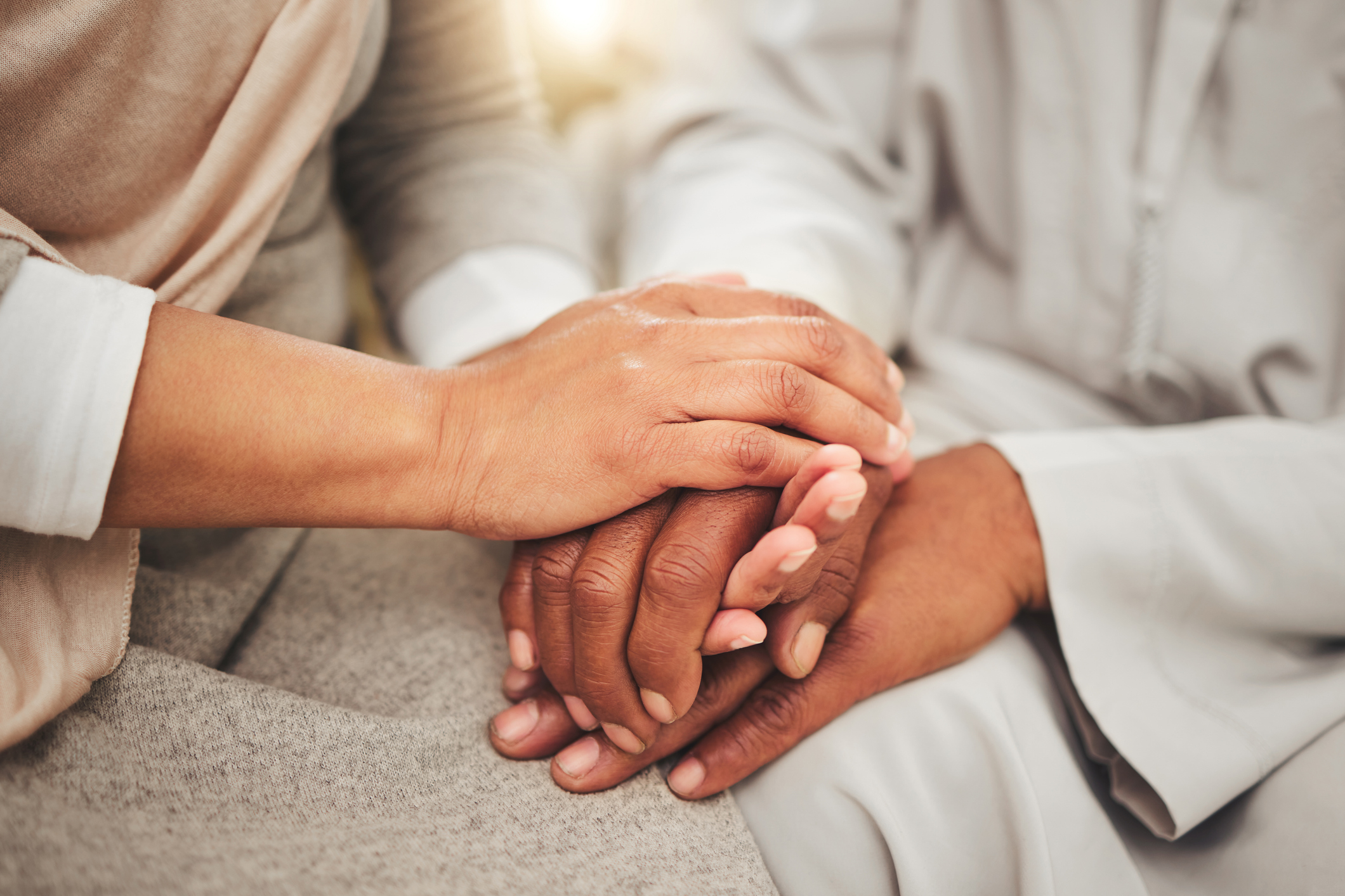 Two people hold each other&#x27;s hands offering comfort and support