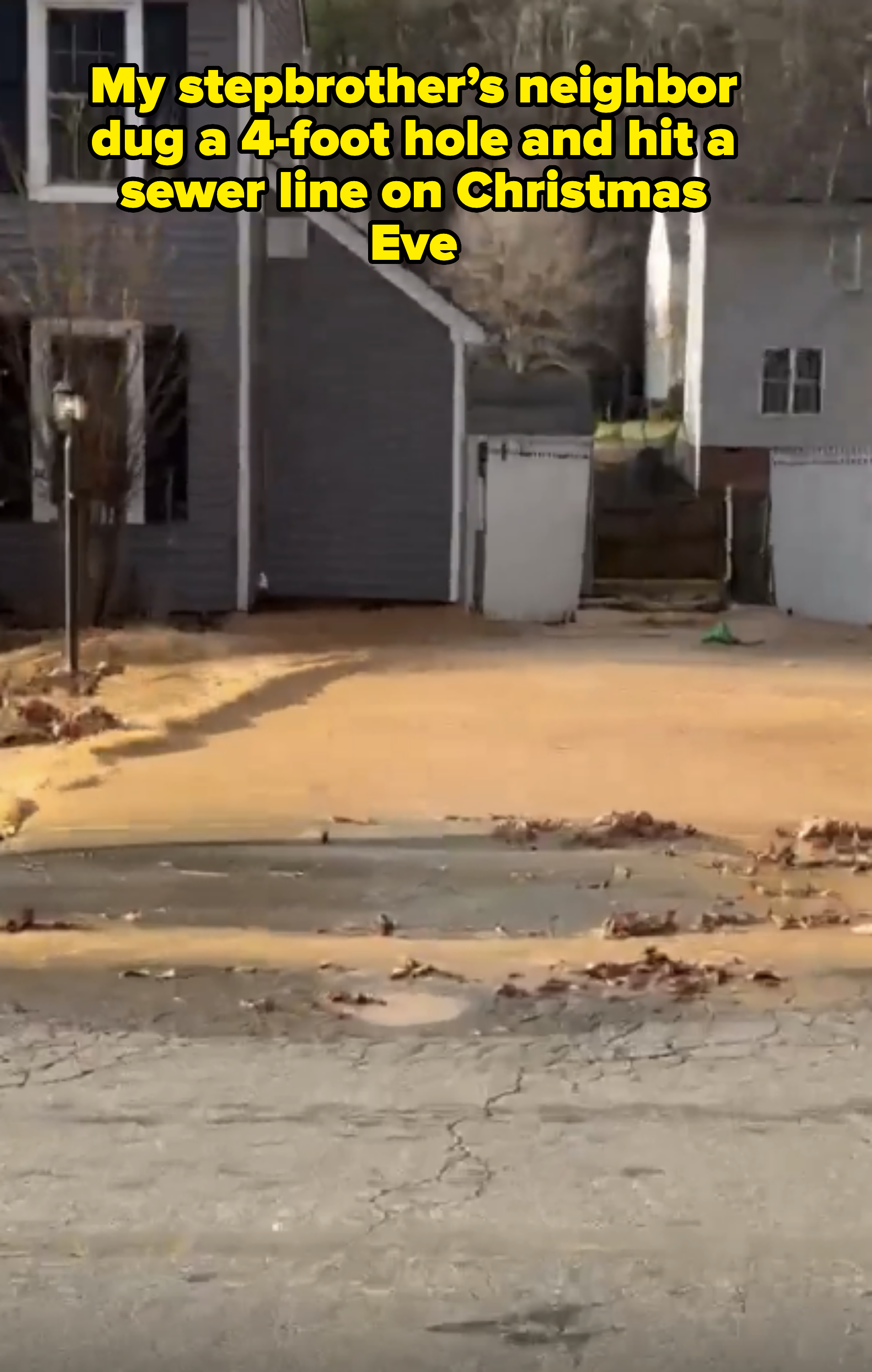 The image shows a residential house with a flooded driveway covered in brownish water and leaves