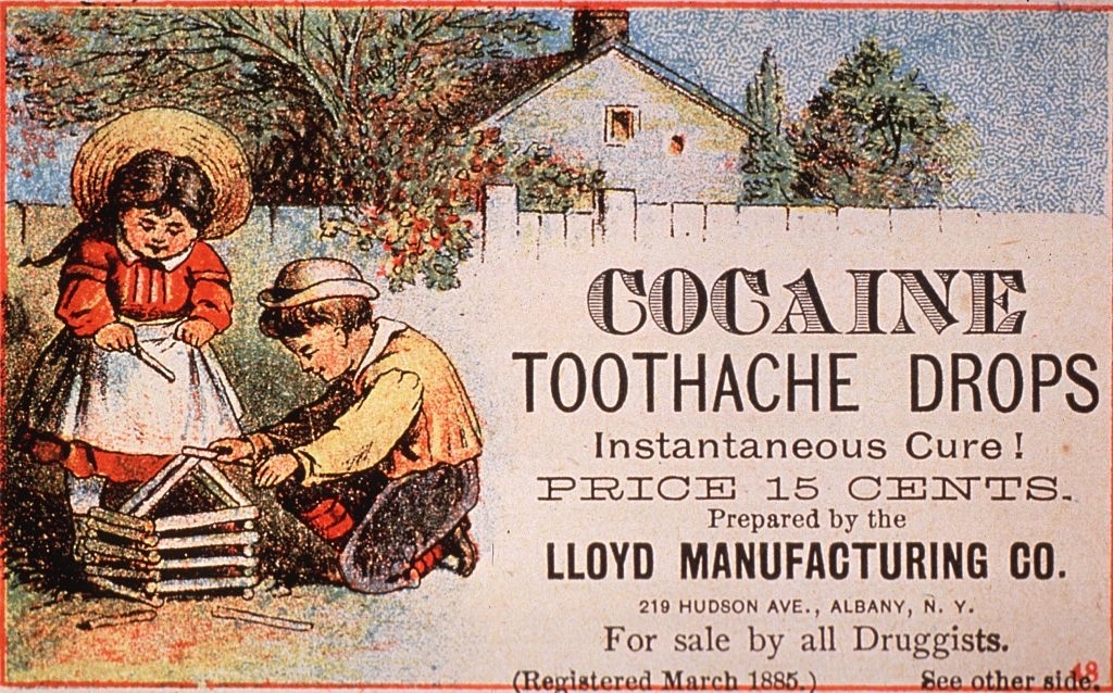 Two children play with a toy house outside; an old advertisement for cocaine toothache drops is displayed, claiming it as an &quot;Instantaneous Cure&quot; for 15 cents