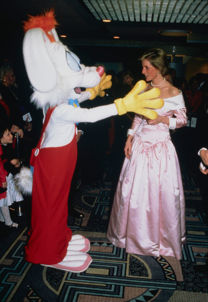 Roger Rabbit character and a woman in an elegant, off-the-shoulder gown engage at a formal event