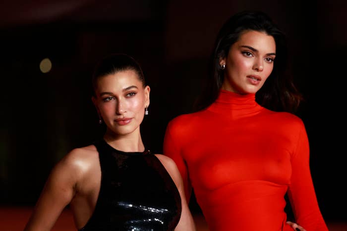 Hailey Bieber in a sleek black dress and Kendall Jenner in a chic long-sleeve outfit pose on the red carpet