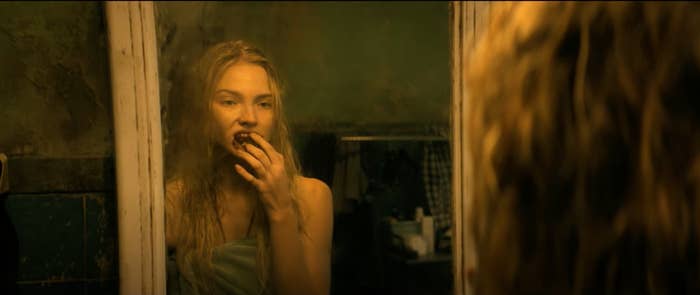 Sasha Luss in Latency looks in mirror with bloody mouth