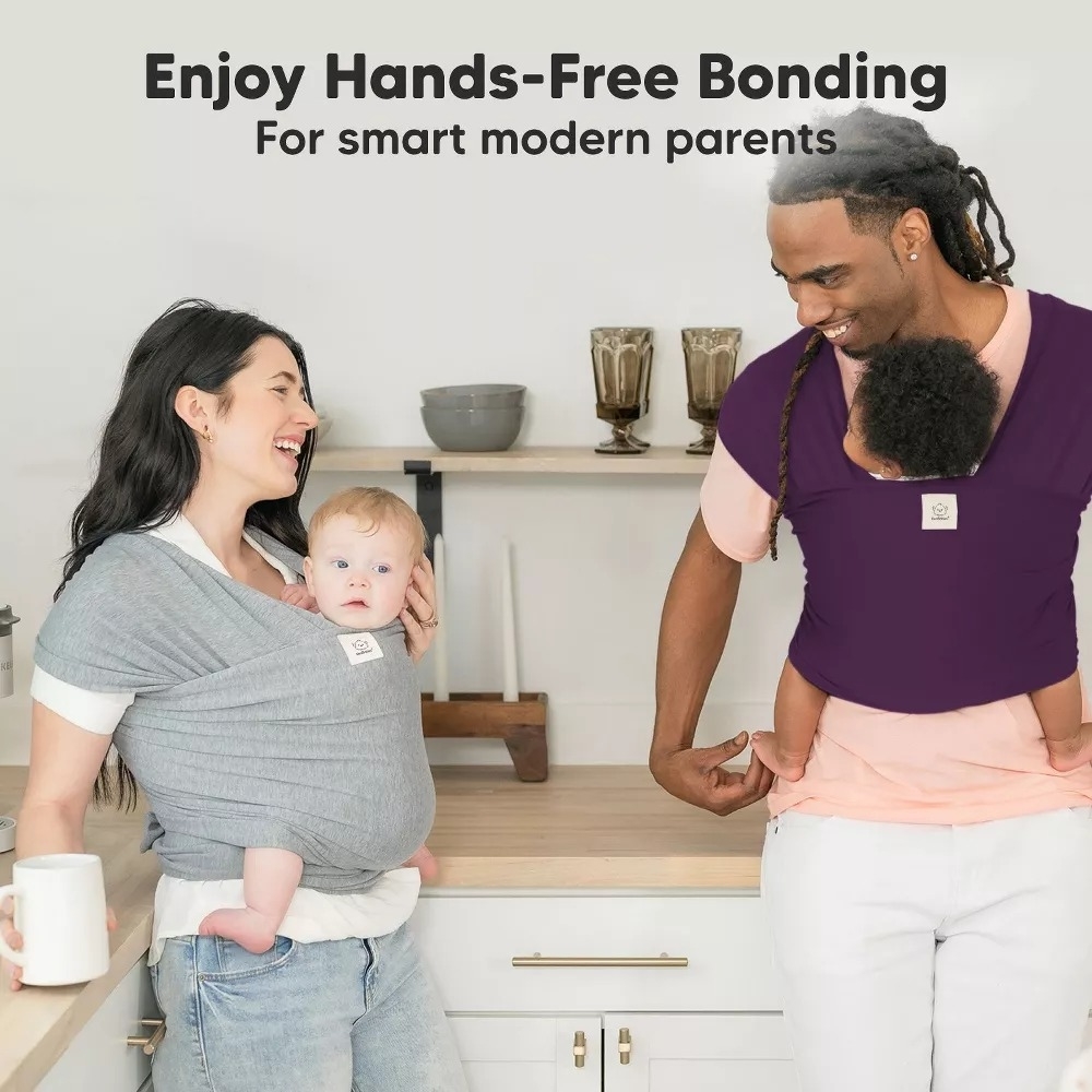 Parents holding their babies in soft carriers stand in a modern kitchen. The text reads: &quot;Enjoy Hands-Free Bonding For smart modern parents.&quot;