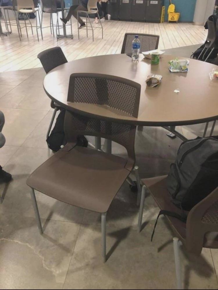 A brown chair is shown with its top going through a table