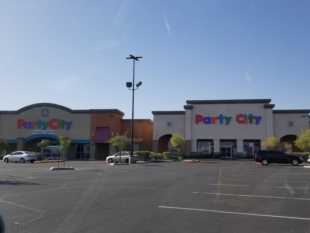 Two Party City stores are located next to each other in a mostly empty parking lot