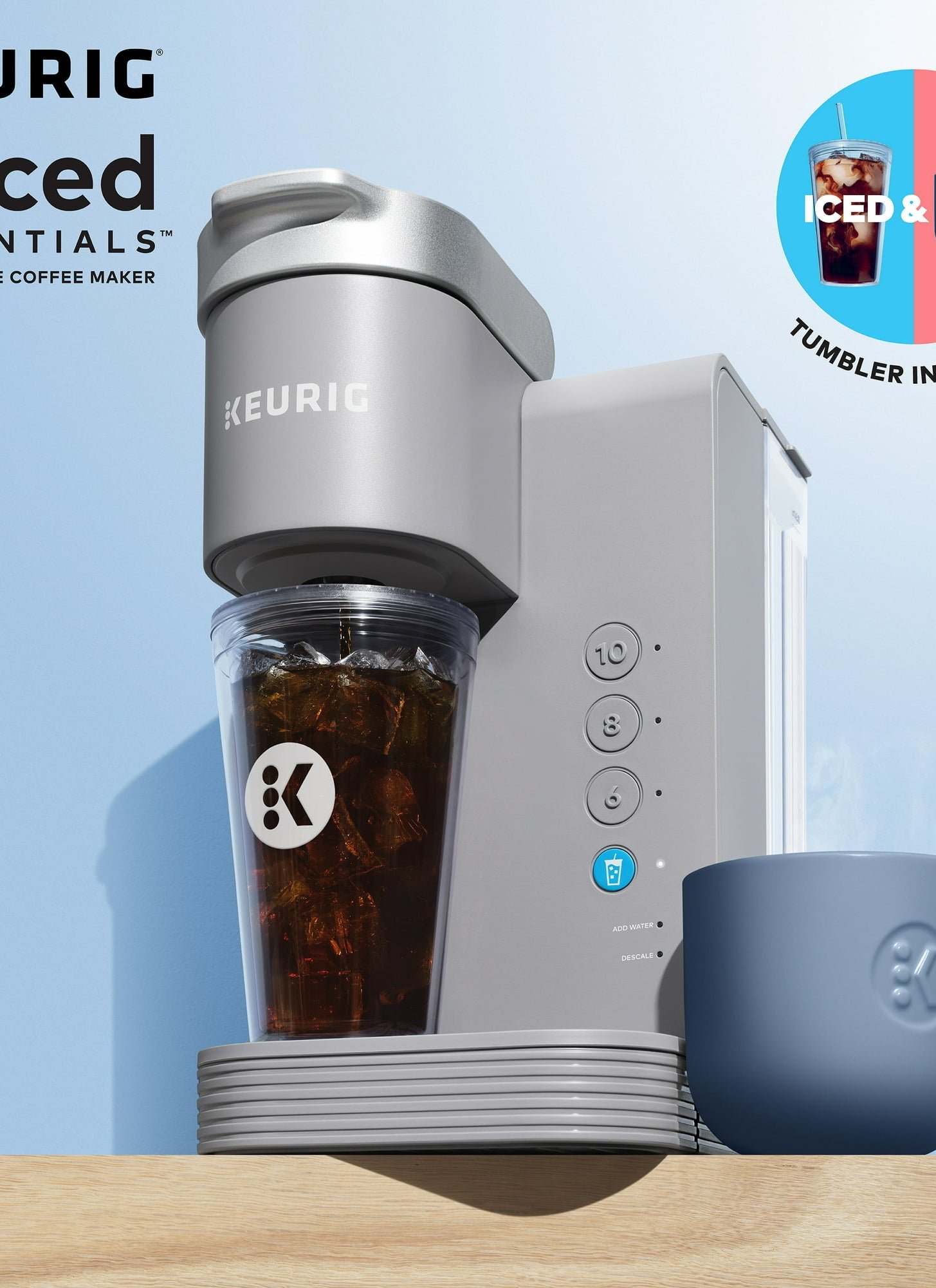 Keurig coffee machine with iced coffee in a tumbler and a hot coffee in a blue mug. Text on the image states, &quot;Iced &amp;amp; Hot, Tumbler included.&quot;