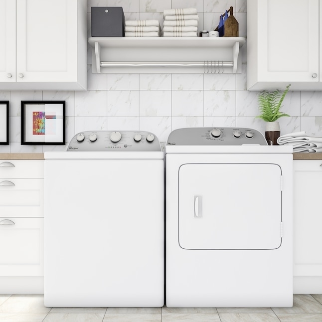 Front-facing view of a laundry room featuring a washer and dryer set. Shelves above hold neatly folded towels and laundry supplies