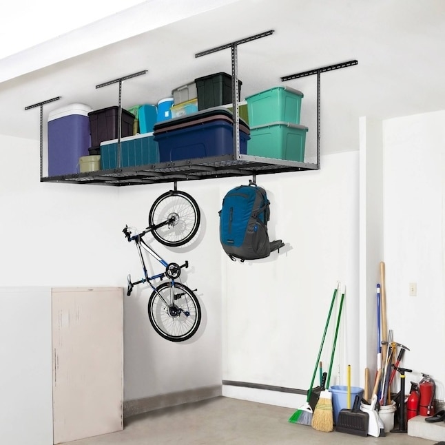 Garage setup with overhead storage holding plastic bins, a bike, and a backpack. Various tools and cleaning supplies are neatly organized beneath