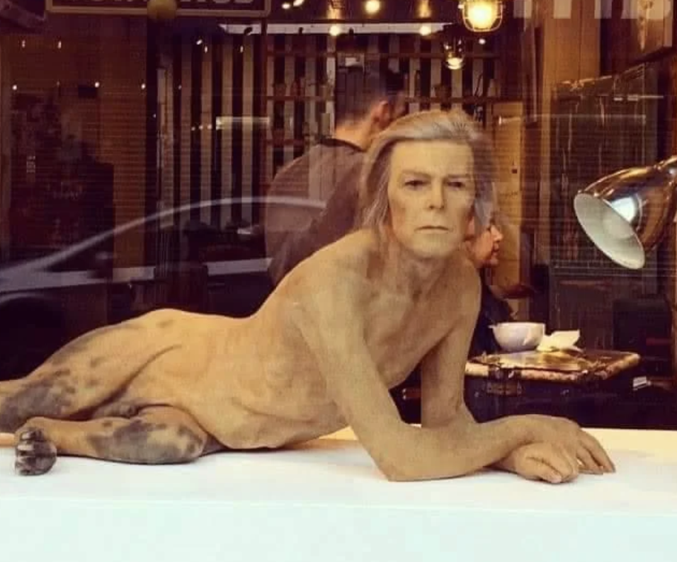 David Bowie nude sculpture/window display in a coffee shop, resembling the character from the movie &quot;The Man Who Fell to Earth.&quot;