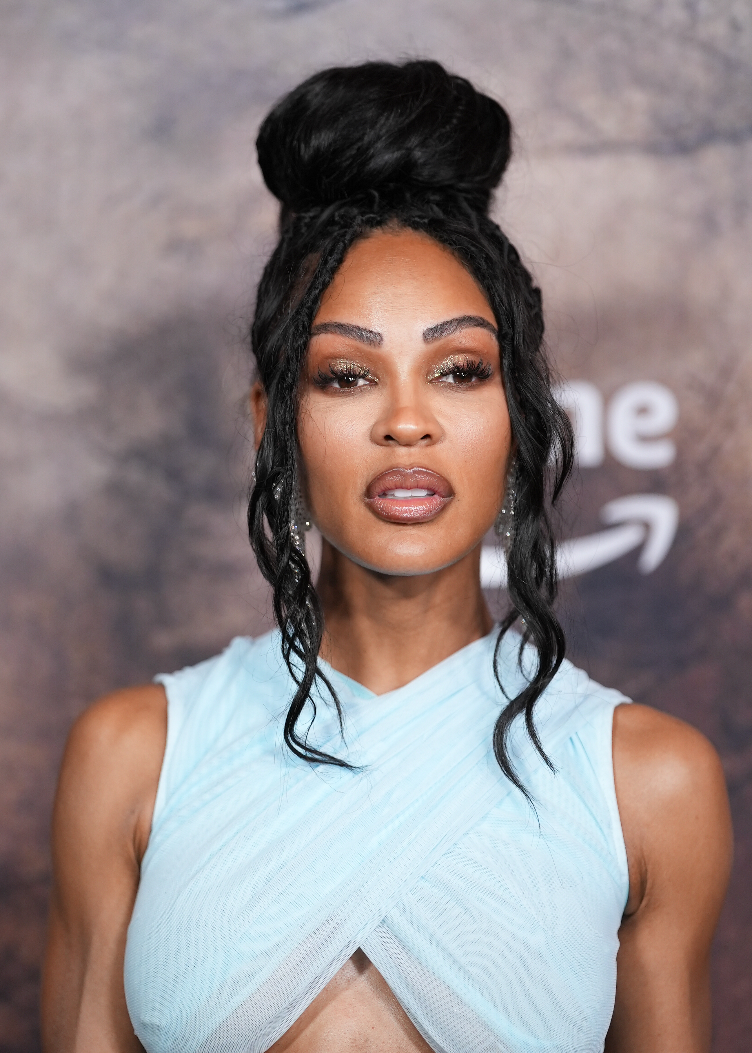 Meagan Good wearing an elegant, sleeveless dress, with an intricate updo hairstyle at a public event