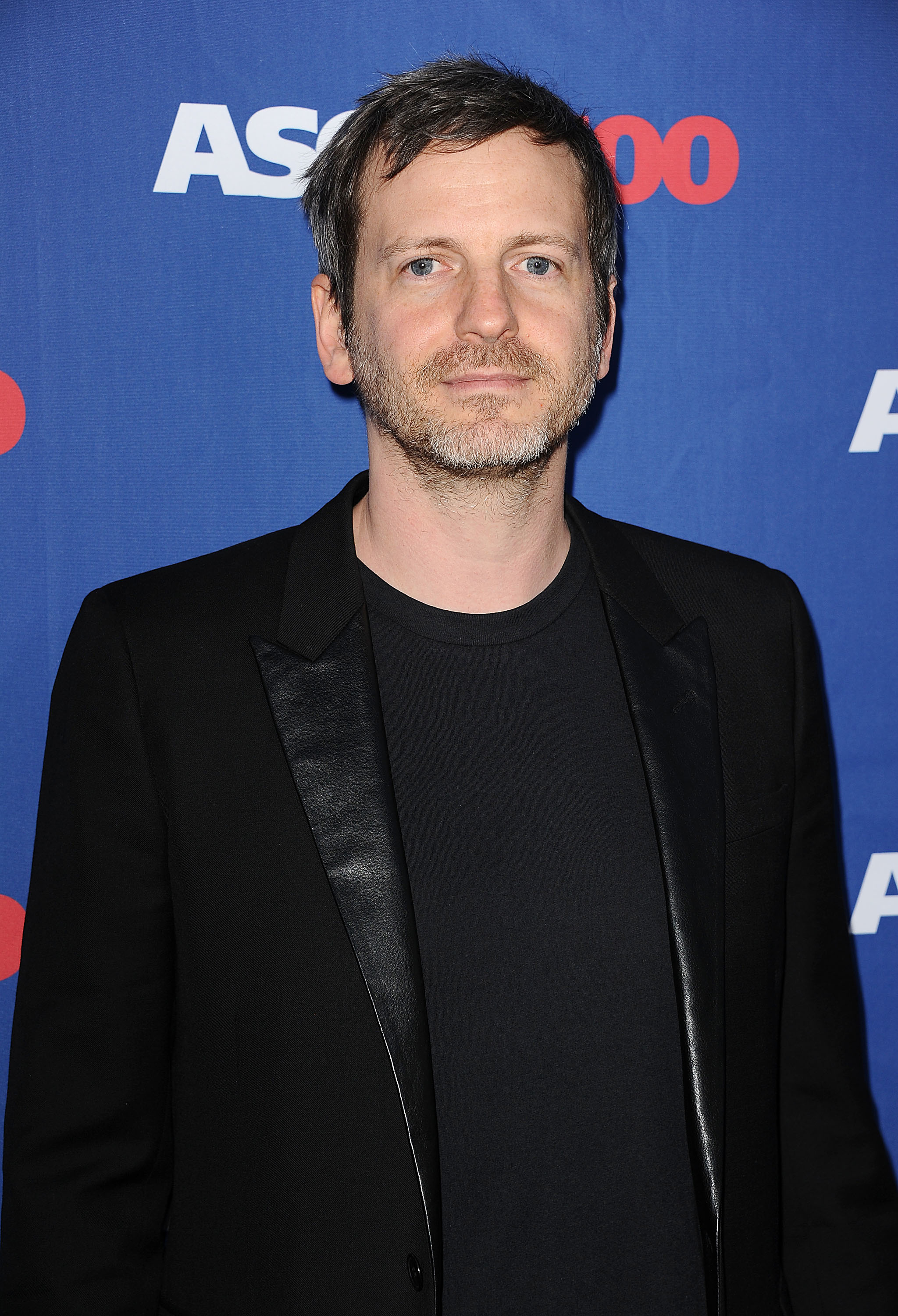 Dr. Luke on the red carpet, wearing a black blazer over a black shirt