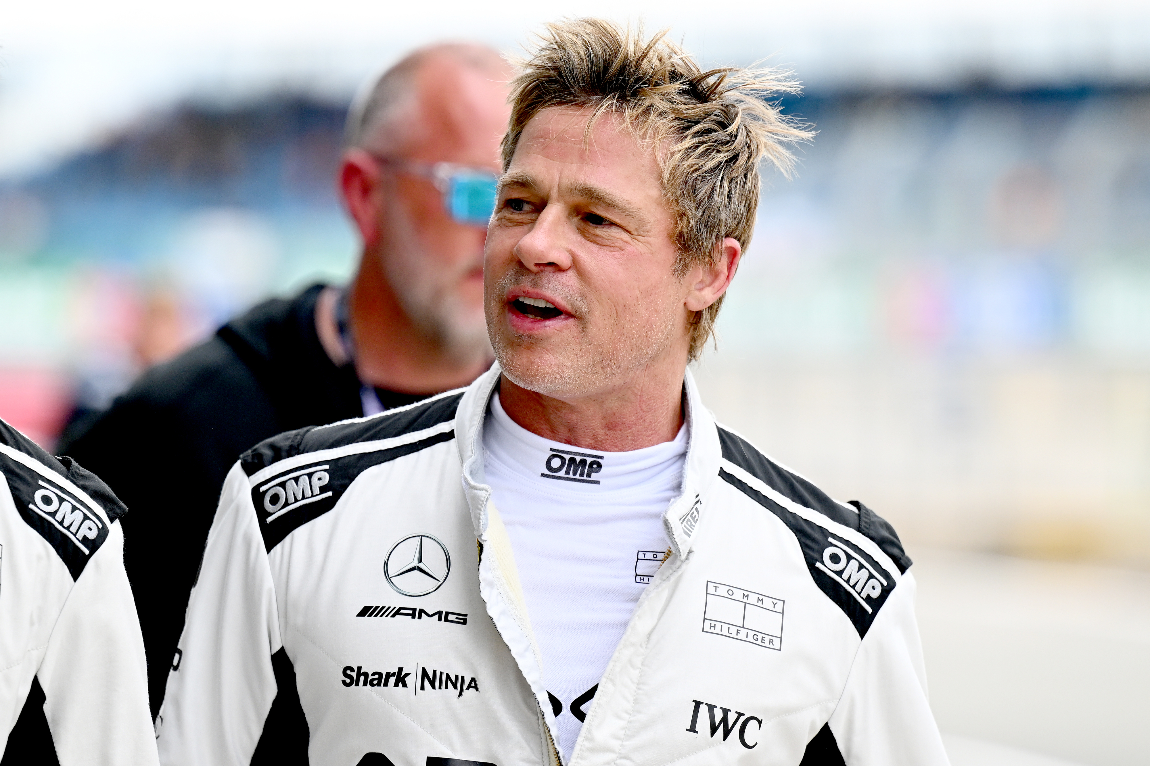 Brad Pitt in a white racing suit with logos,
