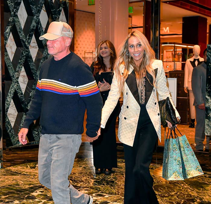 Closeup of Dominic Purcell and Tish Cyrus holding hands while walking