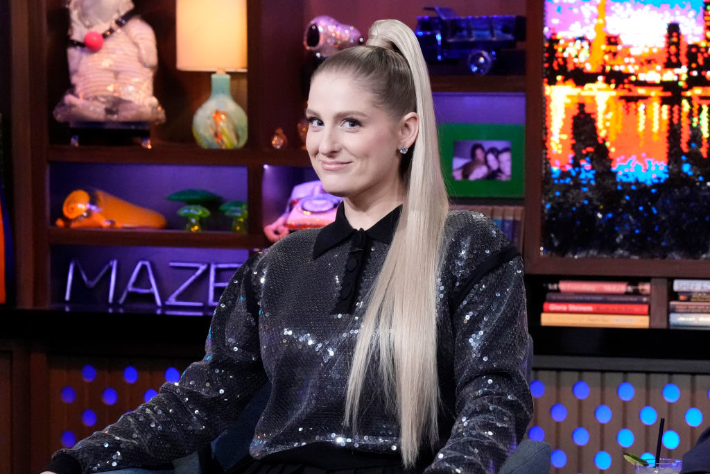 Meghan Trainor in a sequin top with a high ponytail, seated and smiling on a talk show set
