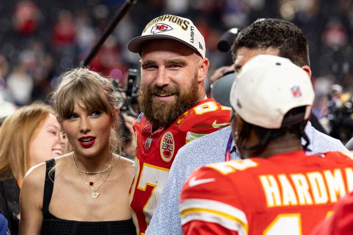 Taylor Swift in a black dress alongside Kansas City Chiefs&#x27; Travis Kelce and Mecole Hardman on the sidelines after a football game