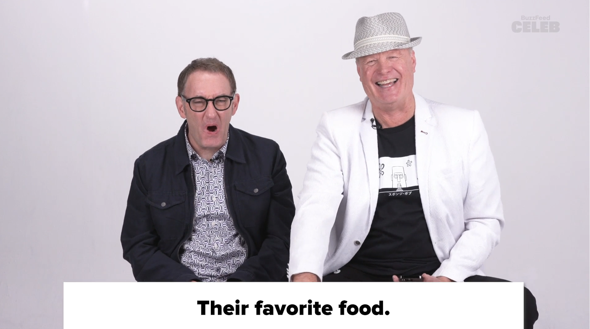 Paul Reubens in a dark jacket and Mark Boone Junior in a white jacket and fedora, sitting next to each other, above the text &quot;Their favorite food.&quot;
