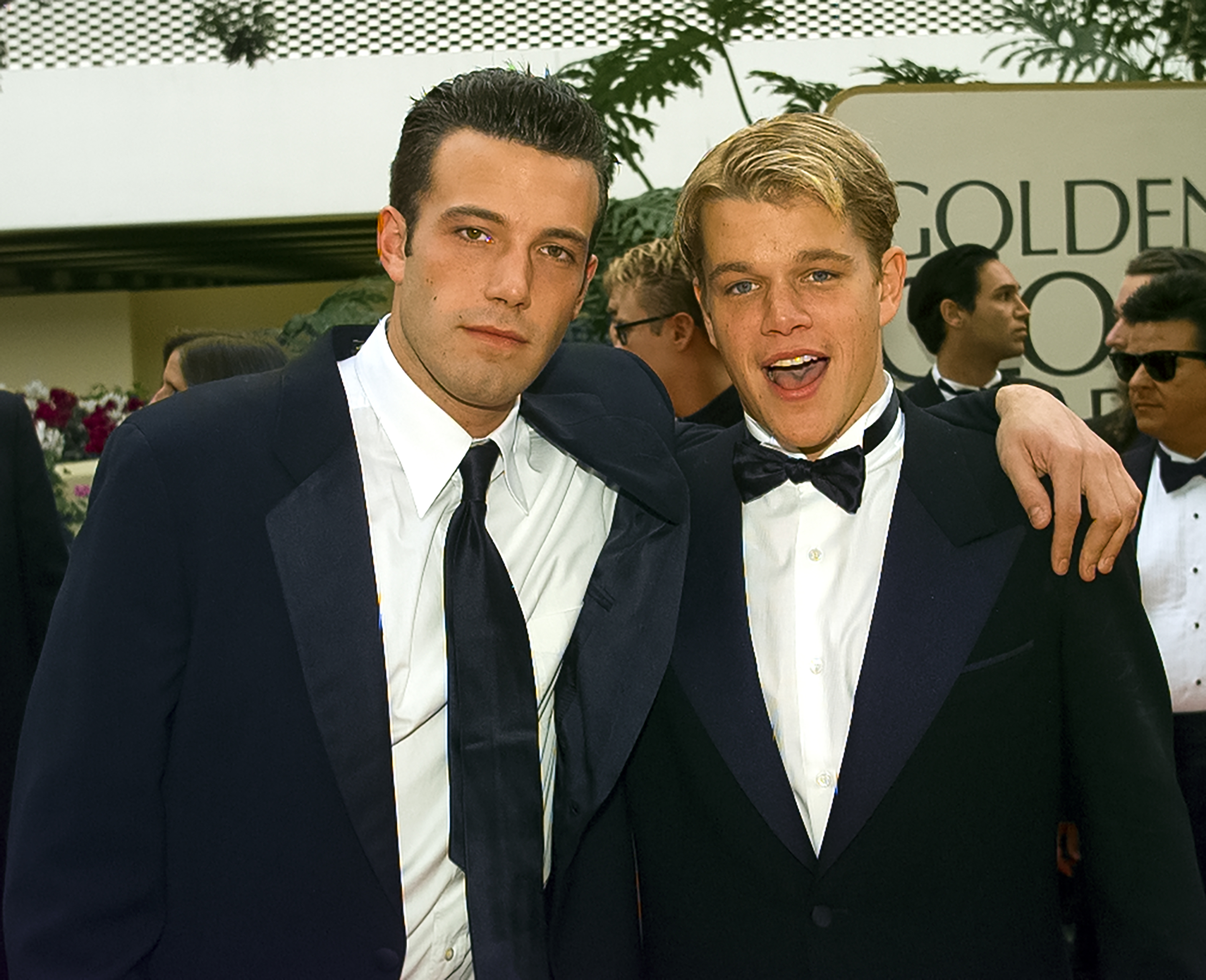 Ben Affleck and Matt Damon in tuxedos, standing together at an event