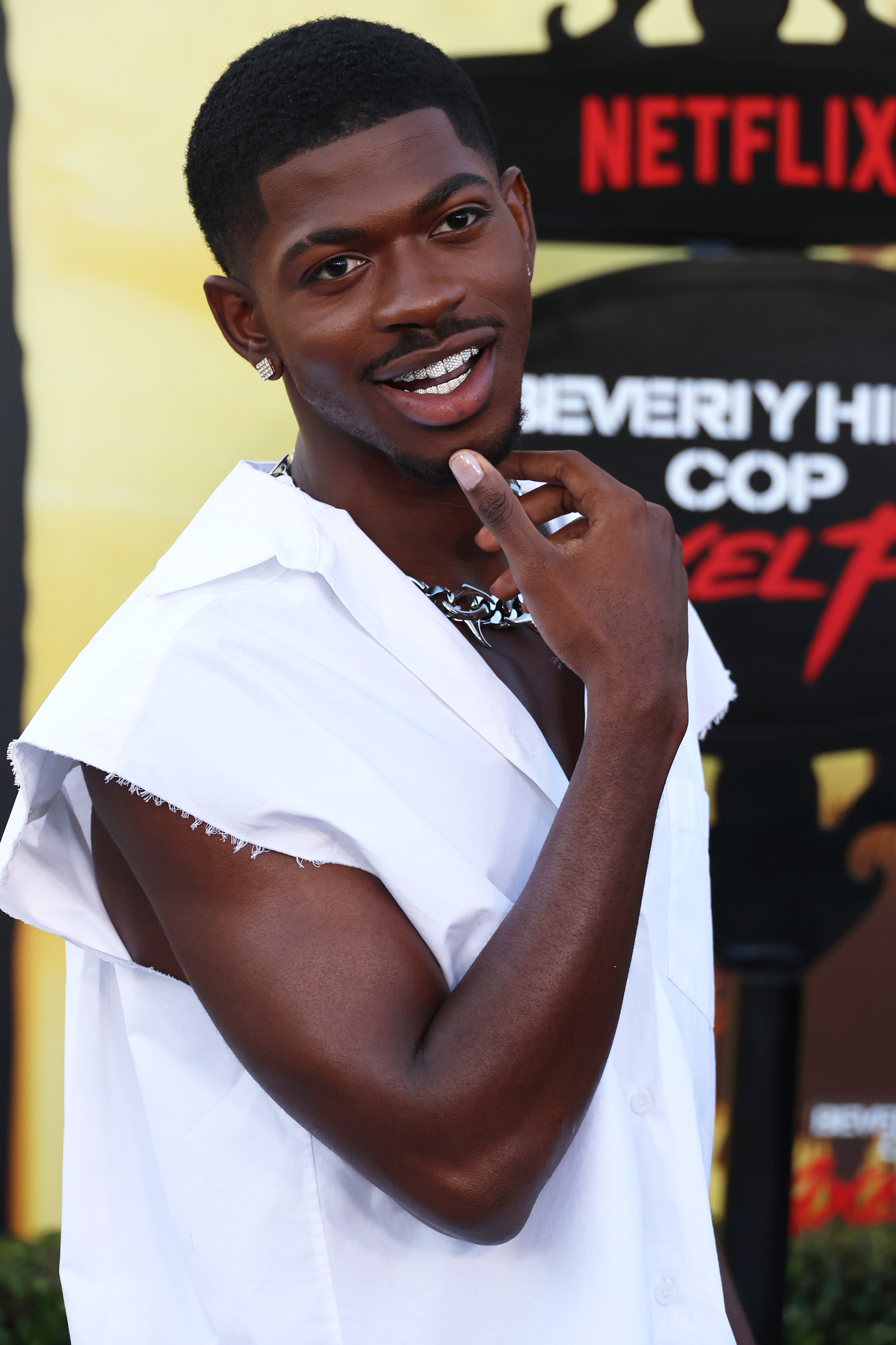 Lil Nas X in a sleeveless white shirt with a silver chain necklace at the Netflix premiere of &quot;Beverly Hills Cop: Axel Foley.&quot;