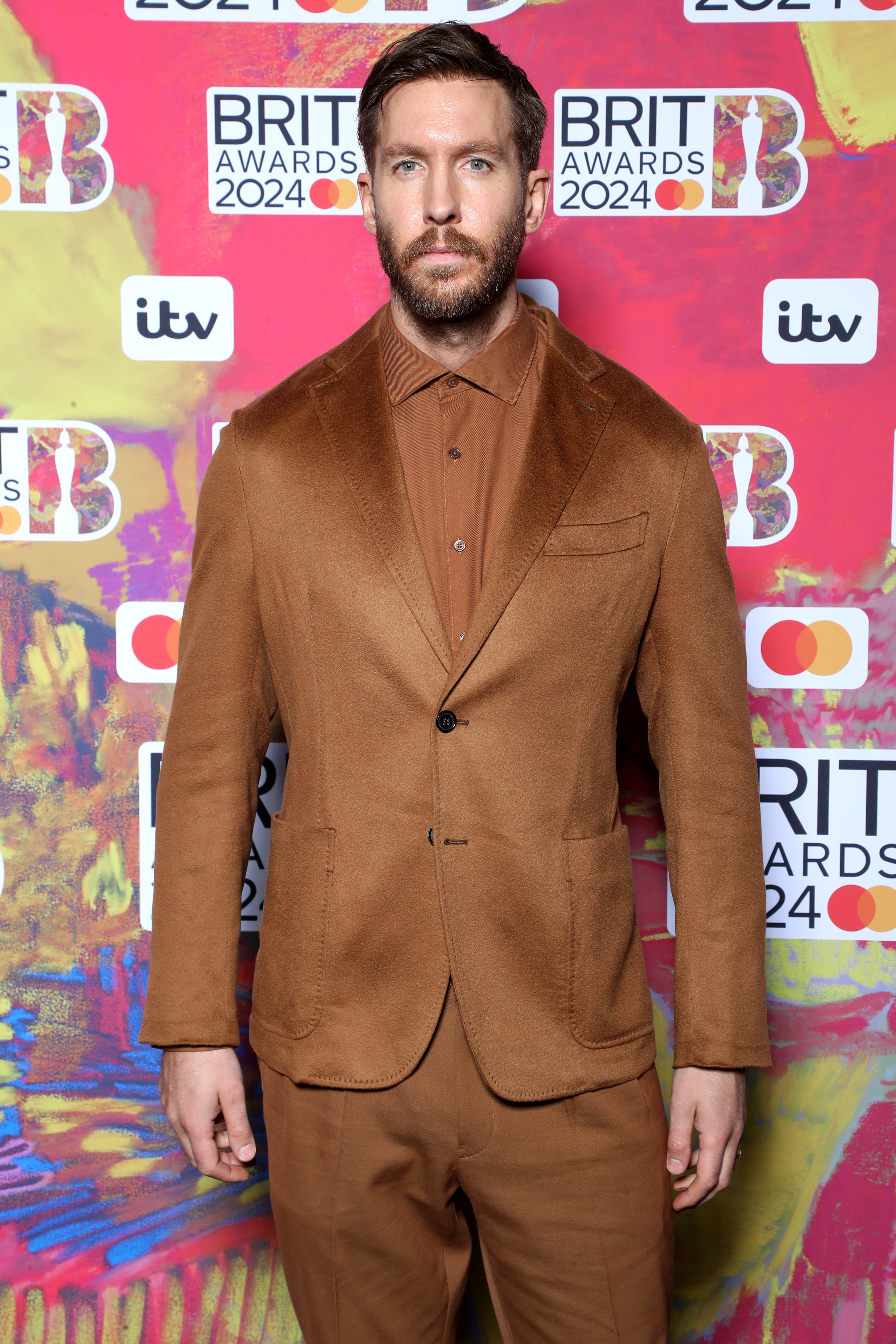 Calvin Harris in a brown suit at the BRIT Awards 2024 red carpet
