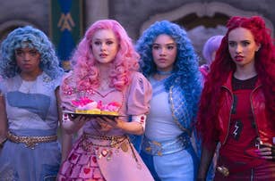 Four teens in bright blue, pink, and red outfits looking annoyed.