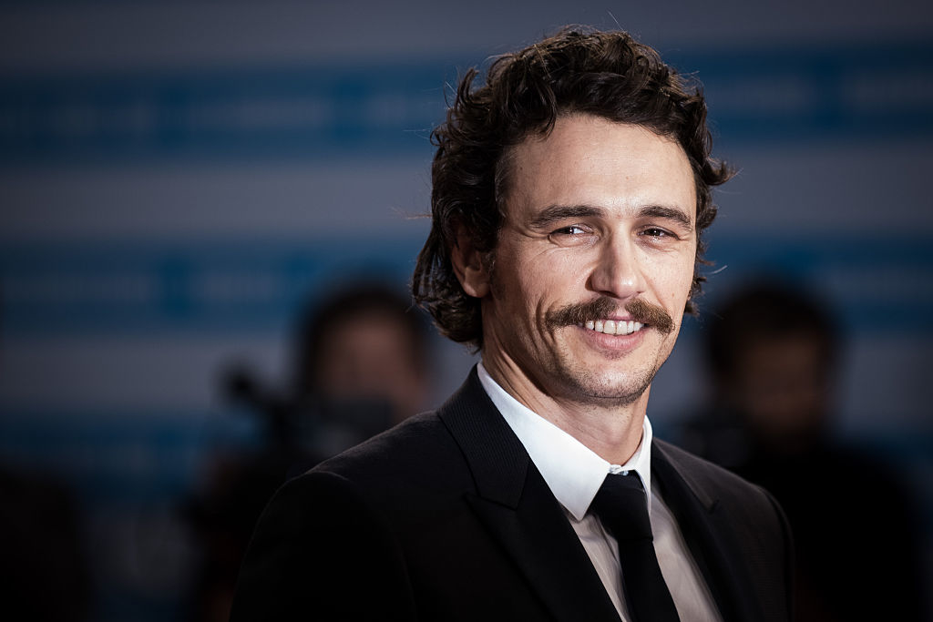 Smiling James Franco wearing a suit and tie at a formal event