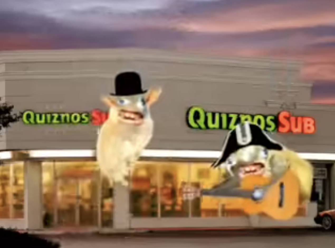 Two characters, one wearing a top hat and another in a tricorn hat with a guitar, appear in front of a Quiznos Sub restaurant