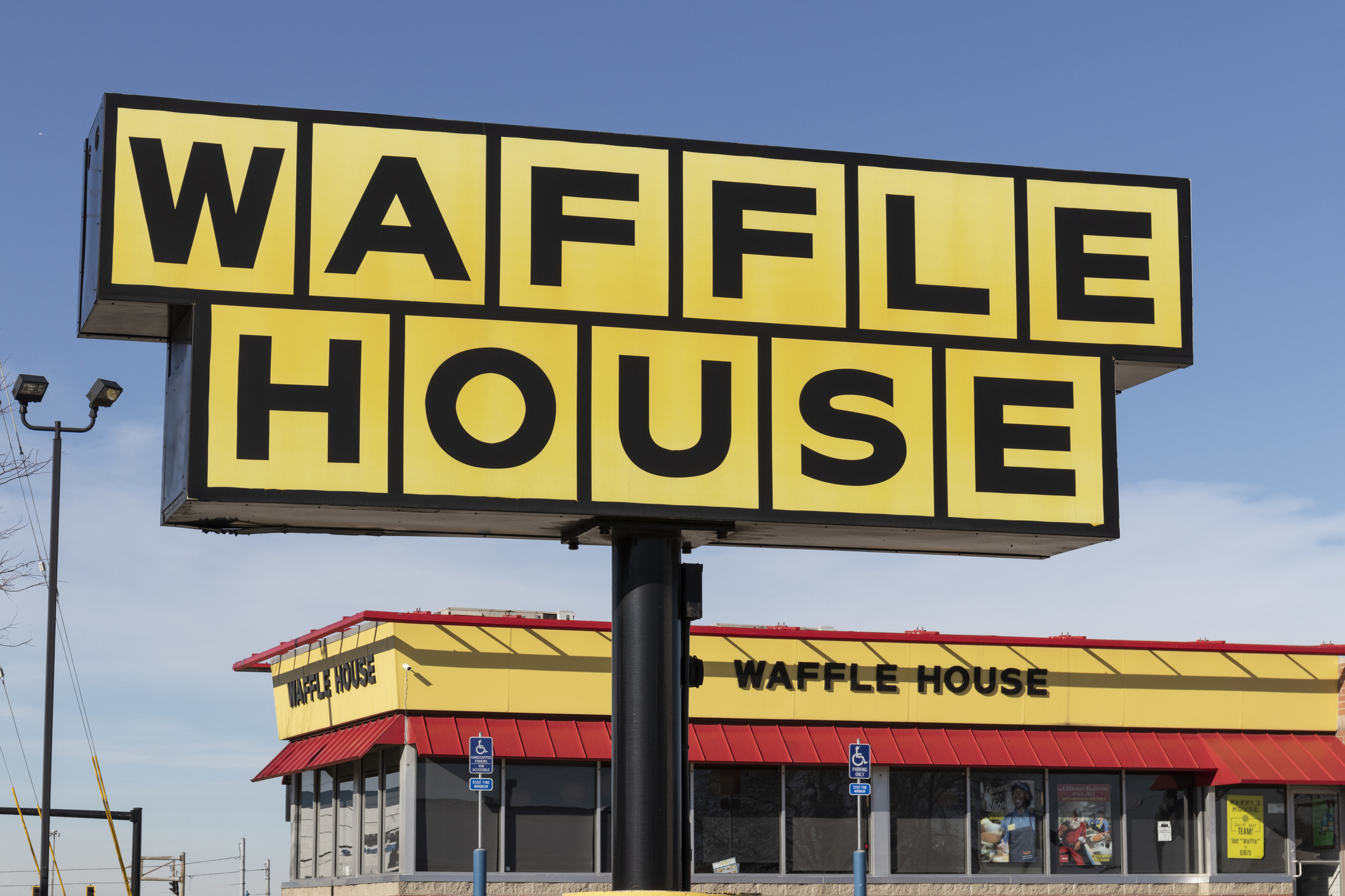 Waffle House restaurant exterior with bold signage in foreground and building in background