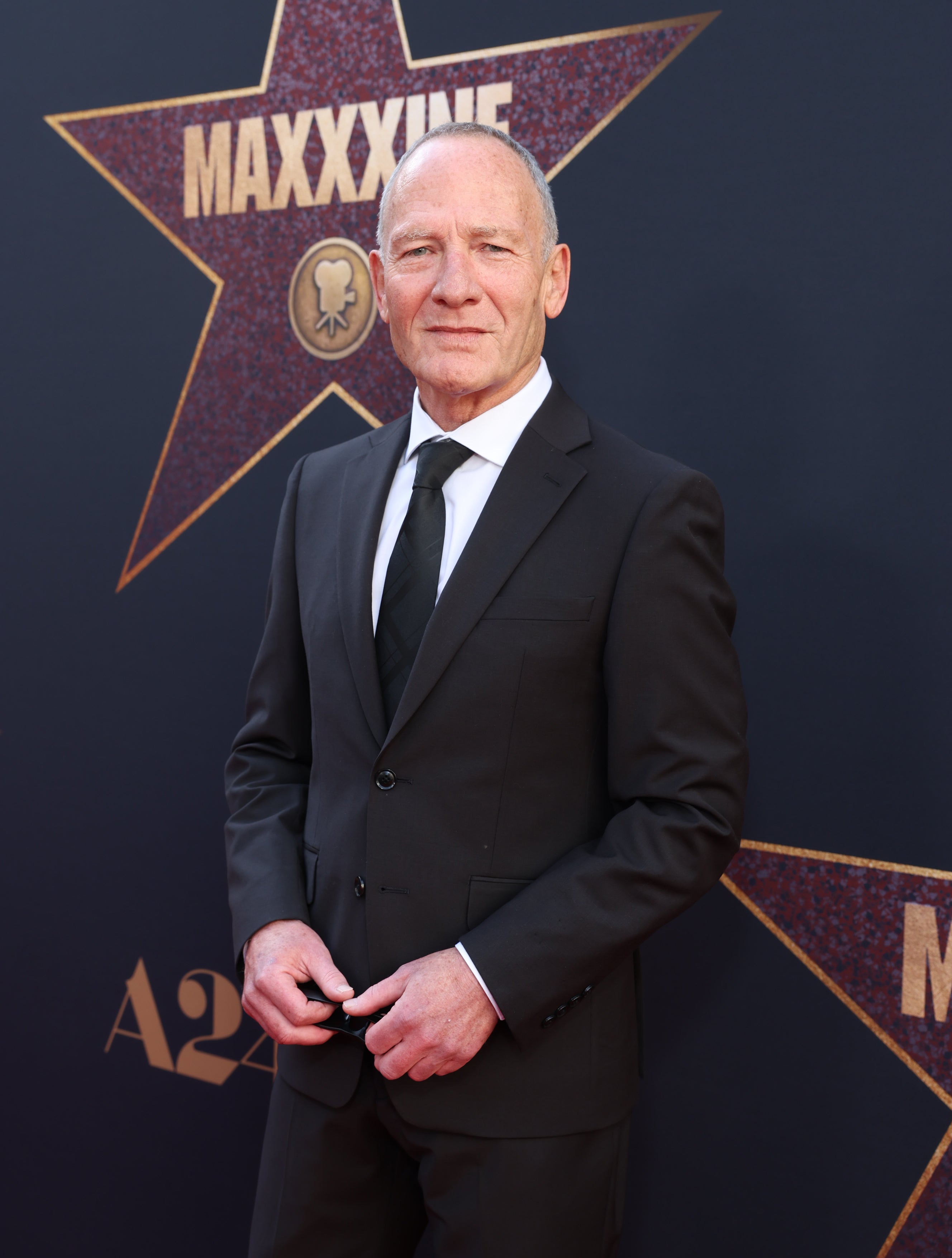 Simon Prast in a suit and tie at the premiere of &quot;MaXXXine&quot;