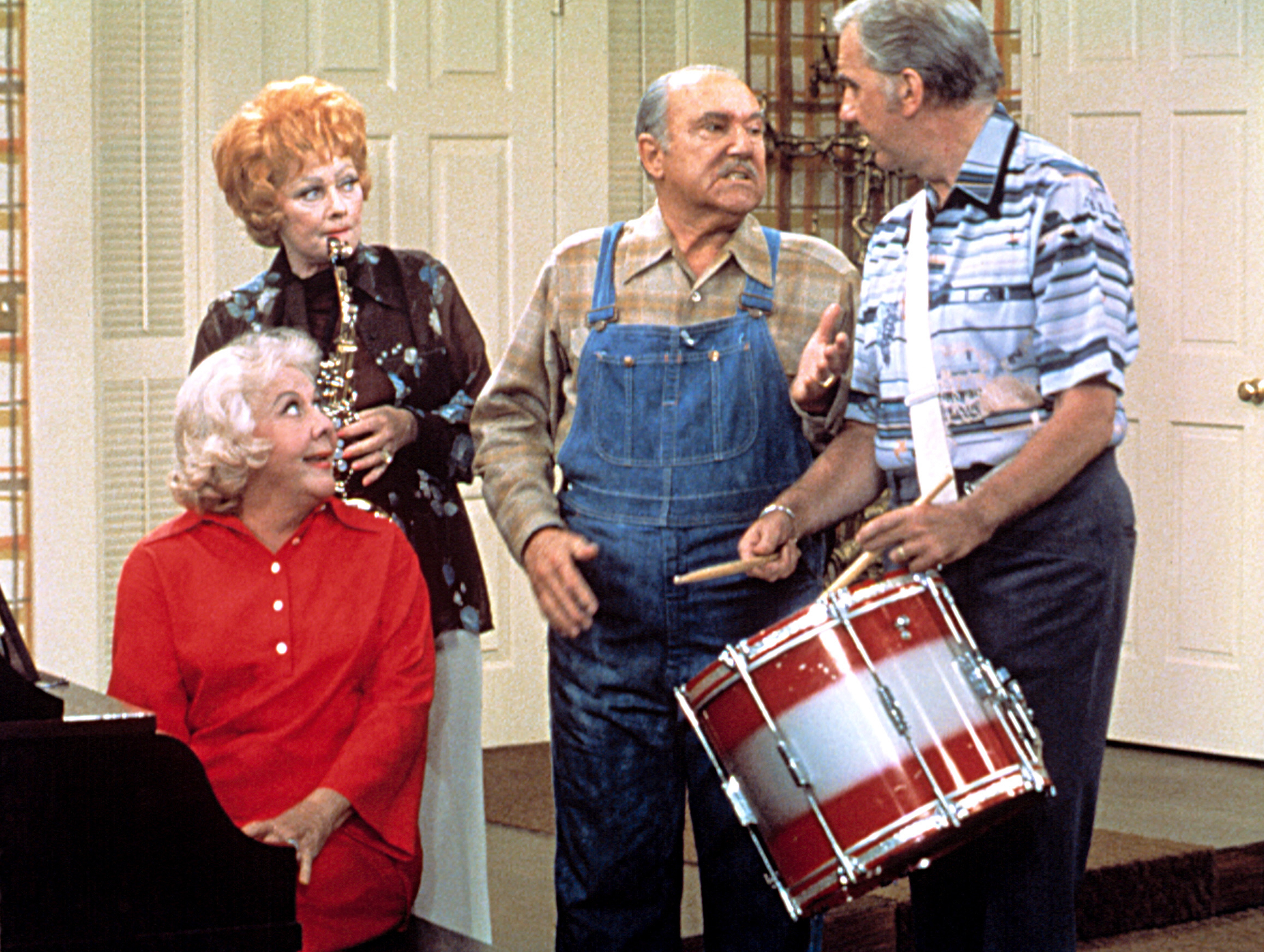 Lucille Ball plays the clarinet, Gale Gordon wears overalls, Vivian Vance sits at the piano, and William Frawley holds a drum in a comedic scene from &quot;The Lucy Show.&quot;