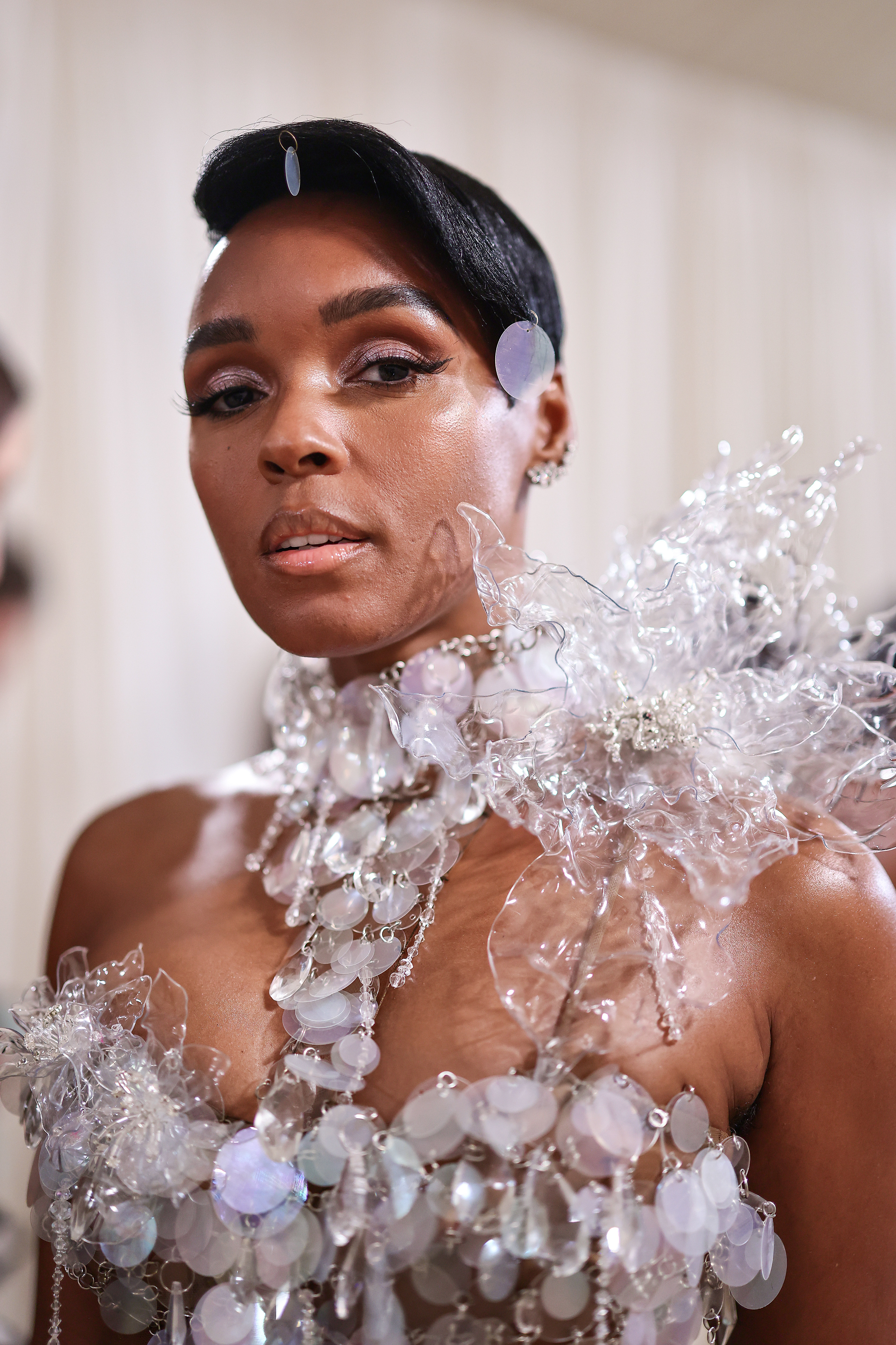 Janelle Monáe in an avant-garde outfit with intricate clear and holographic embellishments, attending a celebrity event