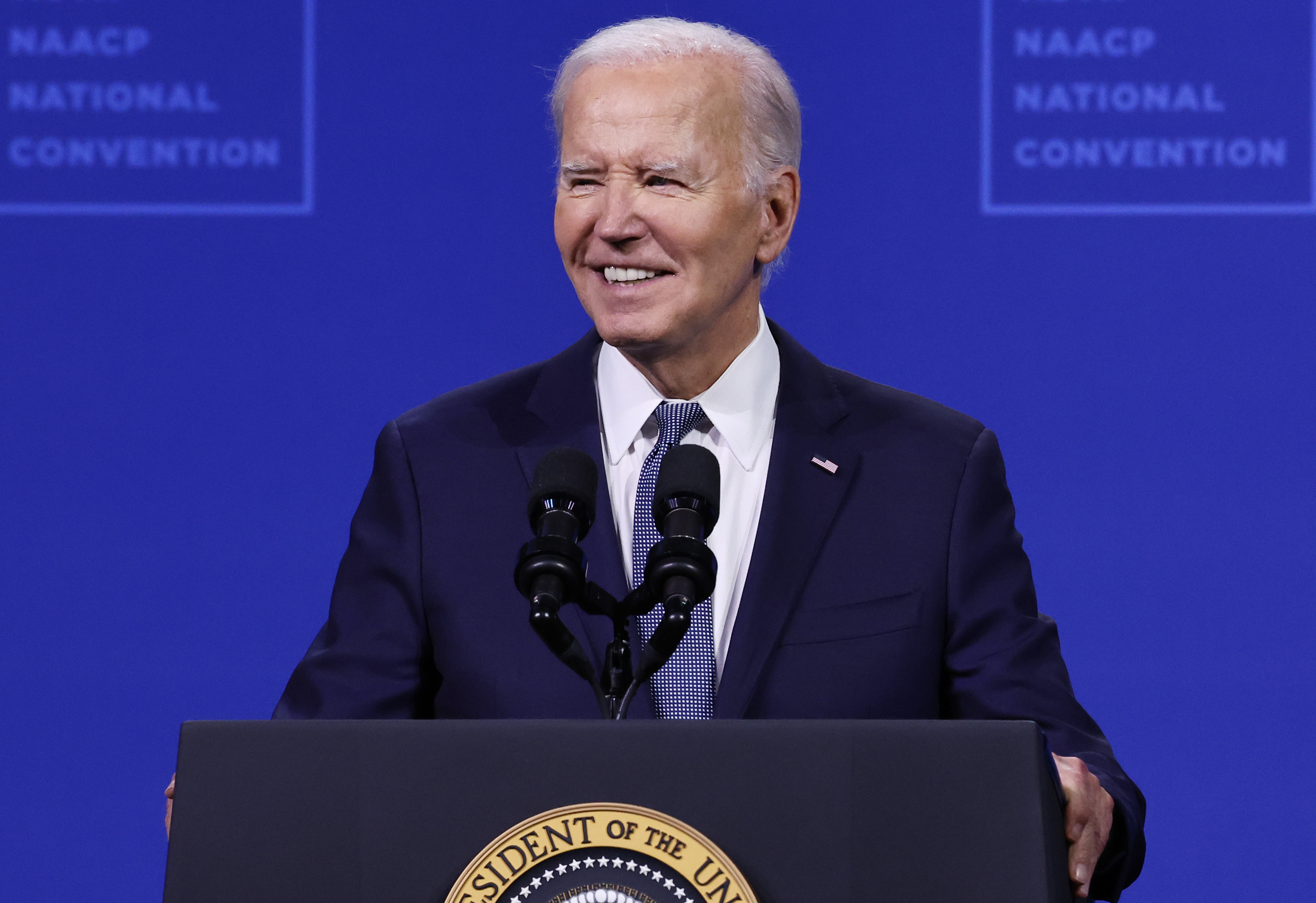 Joe Biden speaks at the NAACP National Convention, standing at a podium with the presidential seal