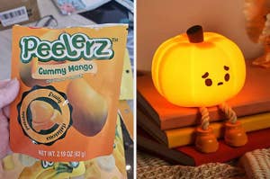 Bag of Peelers Gummy Mango candy held by a hand next to a garden statue of a smiling cat holding a lantern