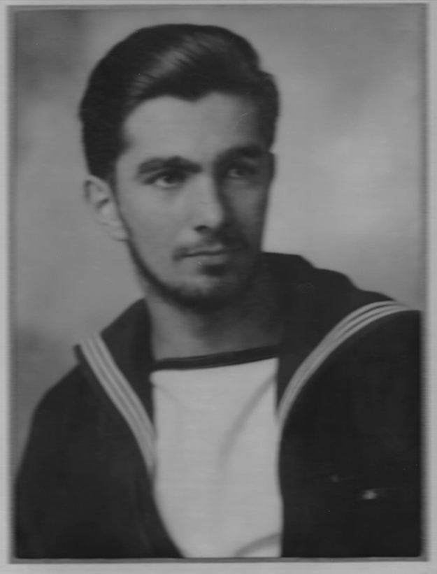 A vintage portrait of a man with short, neatly brushed hair and a trimmed beard, wearing a sailor&#x27;s uniform with a white collar and dark jacket