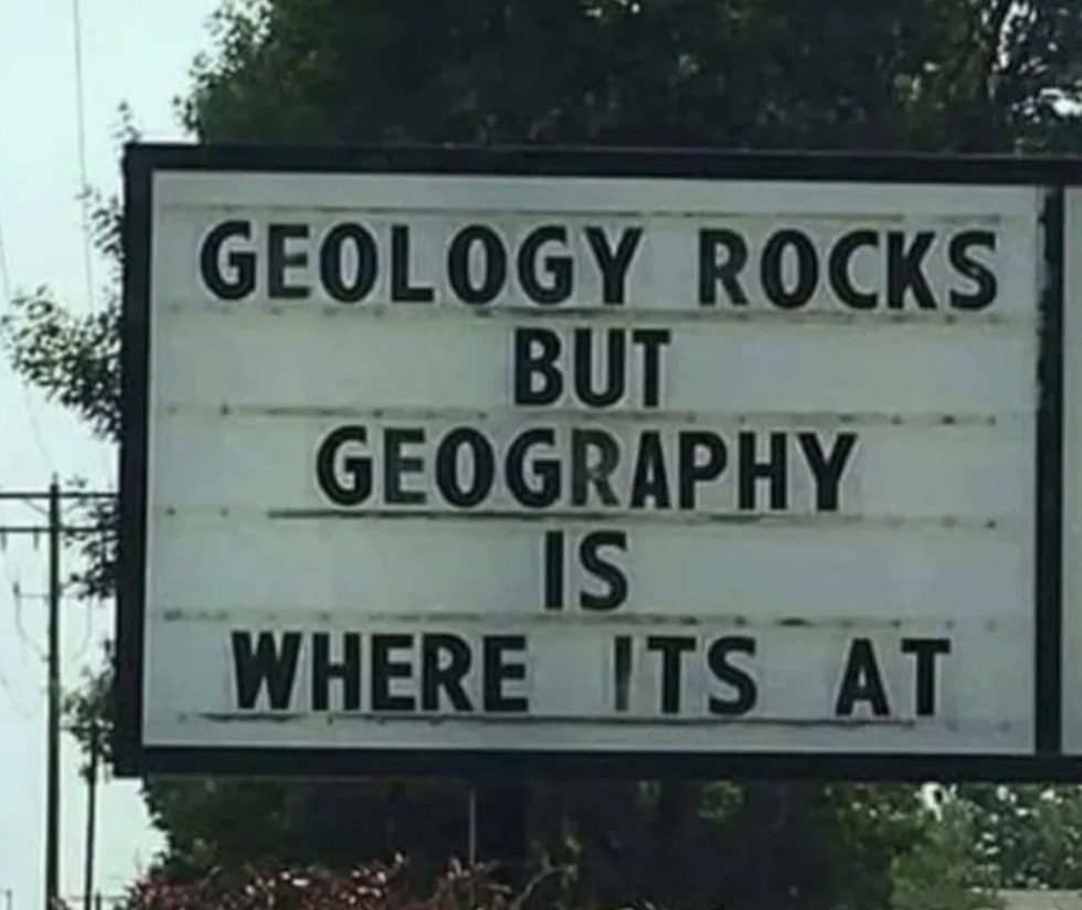 A sign reads, &quot;Geology rocks but geography is where it&#x27;s at.&quot;