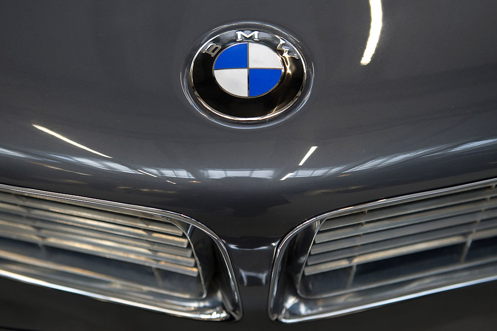 Close-up of a BMW car hood showing the BMW logo and part of the car&#x27;s front grill, highlighting luxury in automotive design