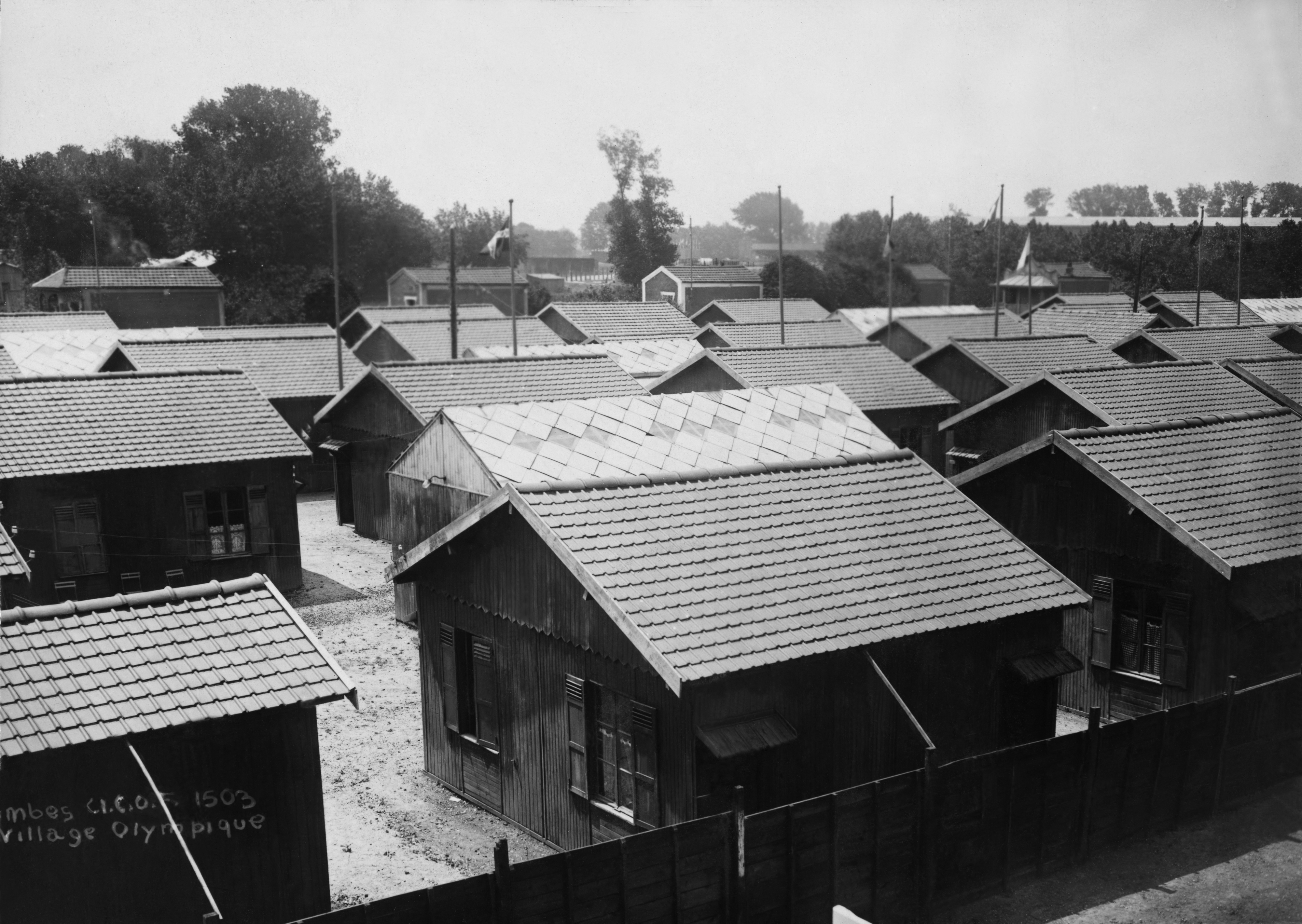 Historic photograph of the Olympic Village in Colombes, France, taken during the 1924 Paris Summer Olympics, showing rows of wooden houses and trees