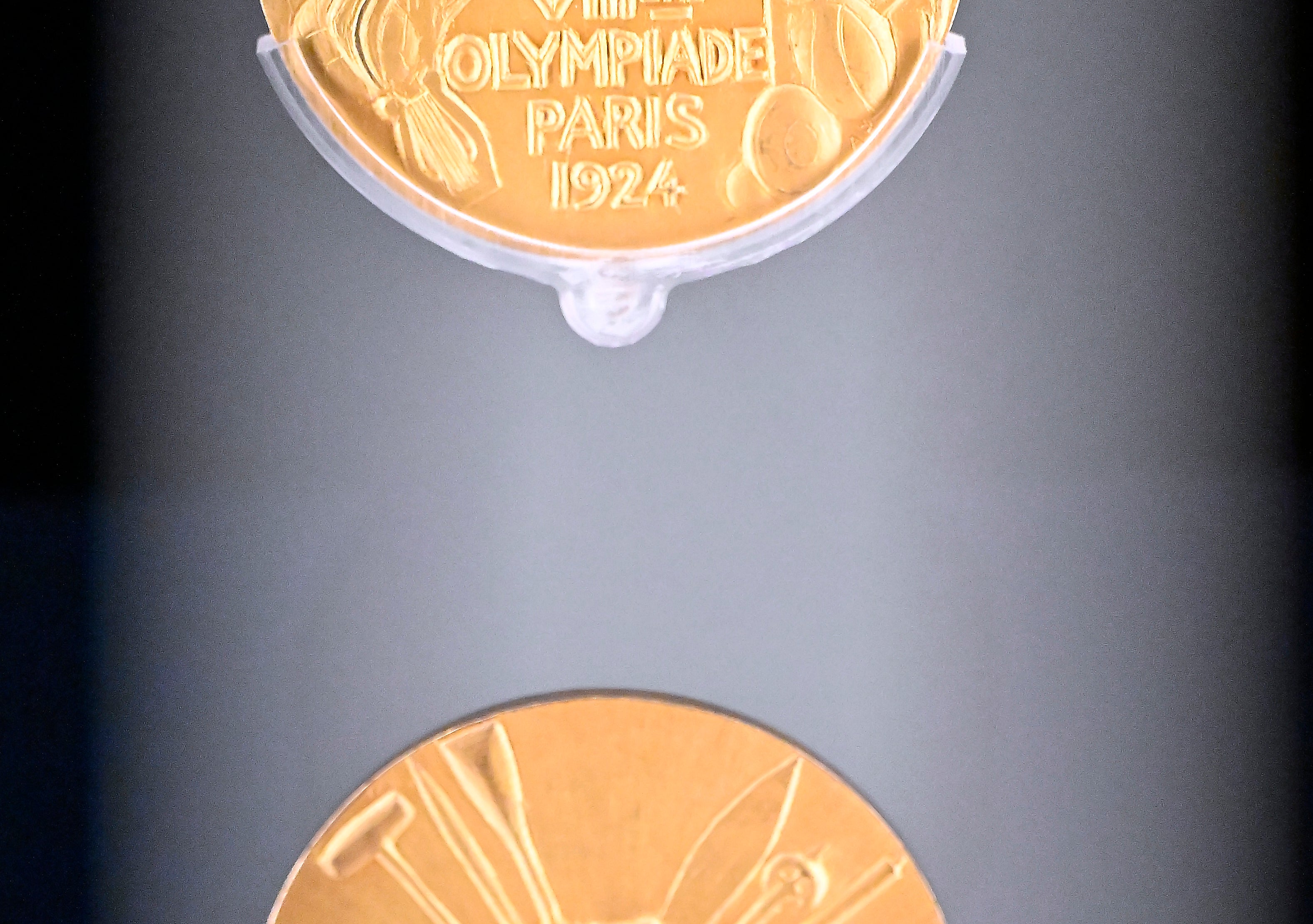 Two gold medals from the 1924 Paris Olympic Games, engraved with &quot;VIII Olympiade Paris 1924&quot; and featuring athletic imagery