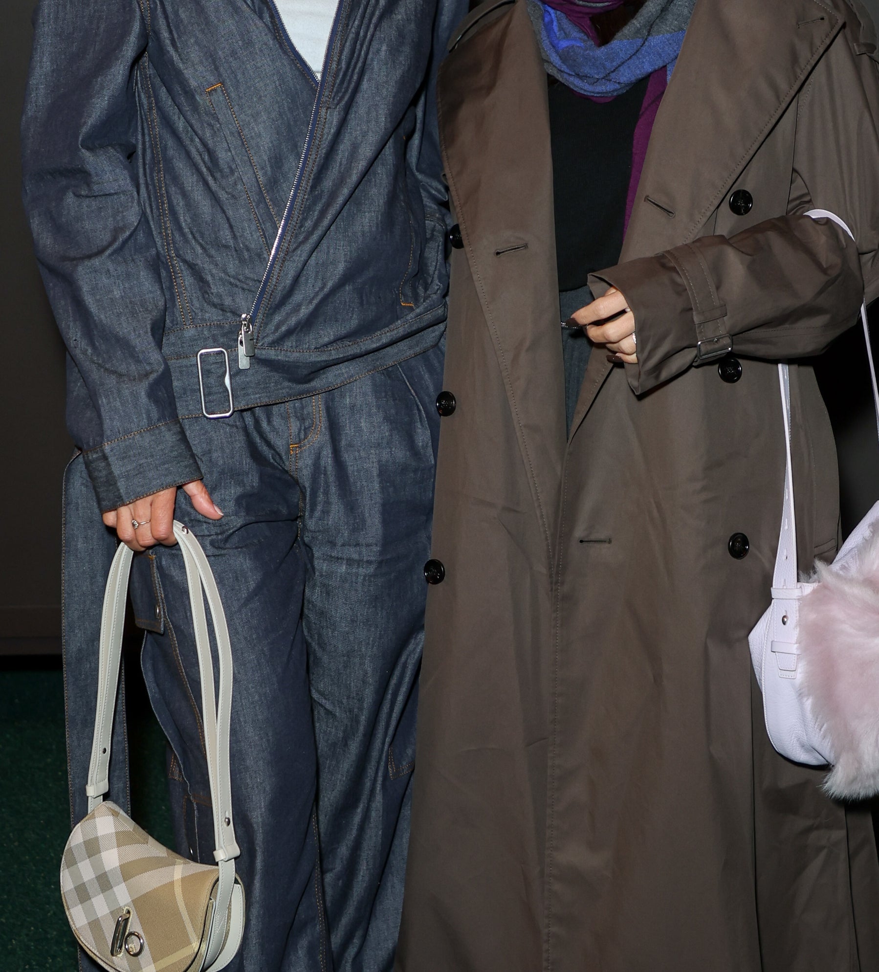 Miquita Oliver in a denim jacket and pants with a shoulder bag, stands next to Lily Allen in a long coat with a fur bag, both posing for a photo