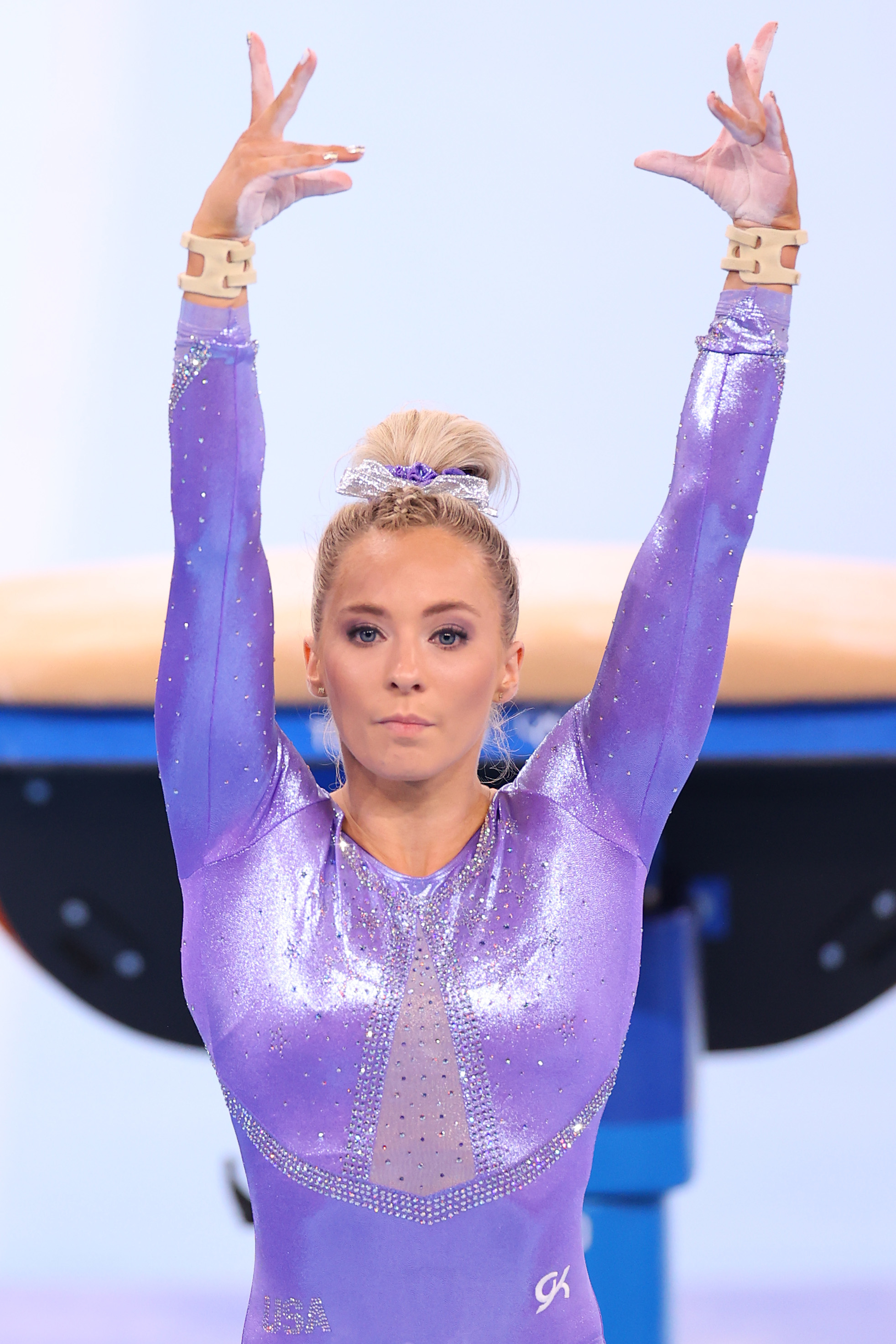 MyKayla Skinner is seen in a sparkly gymnastics leotard with arms raised, preparing for a routine