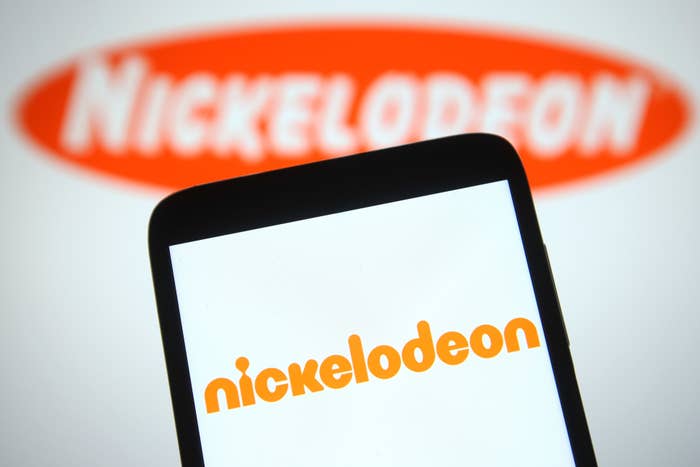 Smartphone screen displaying the Nickelodeon logo, with a larger Nickelodeon logo blurred in the background