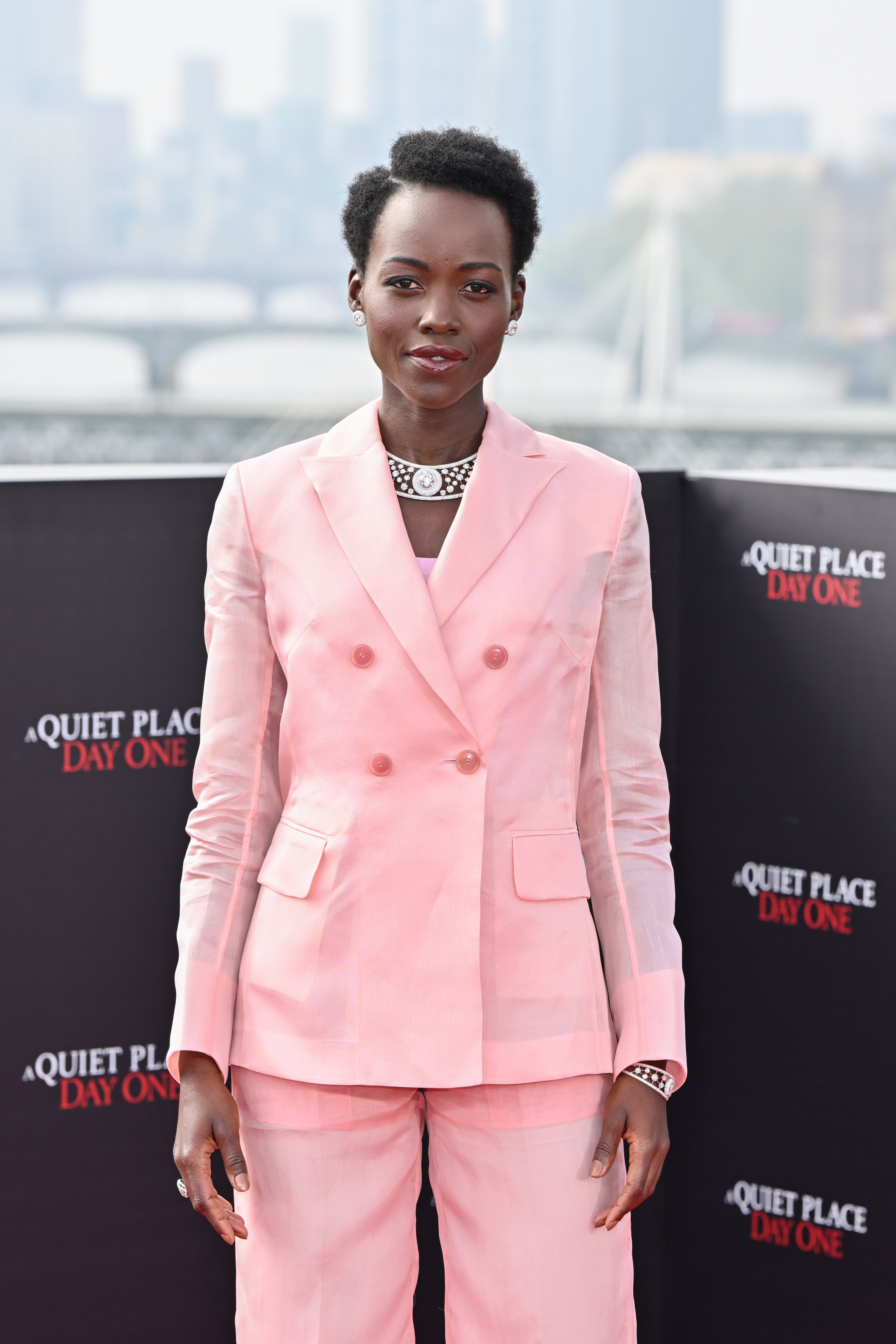 Lupita Nyong&#x27;o at the &quot;A Quiet Place: Day One&quot; event wears a tailored, double-breasted suit with a modern necklace